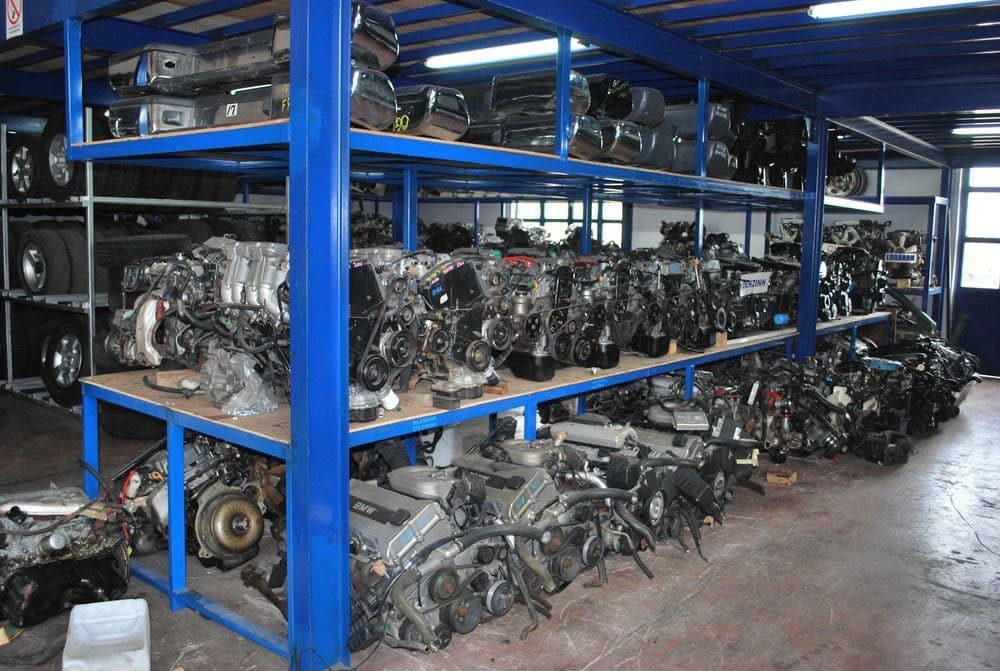 Shelves of complete engines with chrome valve covers stacked on the top shelf